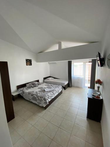 ein Schlafzimmer mit einem Bett in einem weißen Zimmer in der Unterkunft Casa EVY in Eforie Nord