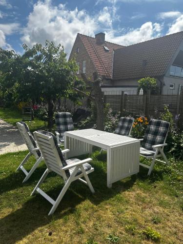 a white table and four chairs in a yard at Brabo källare in Landskrona