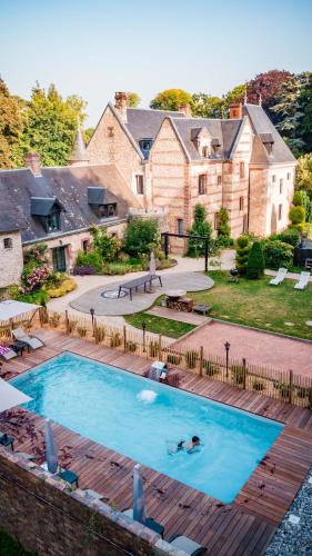 une personne se baignant dans une piscine en face d'une maison dans l'établissement Château de Saint-Clair, à Étretat