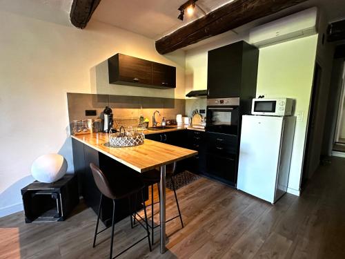 ヴェゾン・ラ・ロメーヌにあるLe Cosy de Montfortのキッチン(木製テーブル、白い冷蔵庫付)