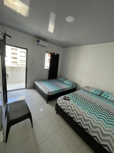 a bedroom with two beds and a chair in it at azul caribe 9-10-12-13 in Gaira