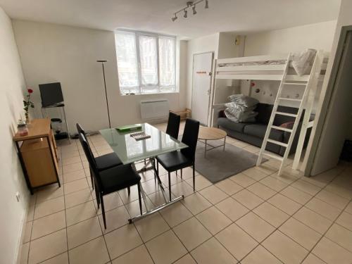 - un salon avec une table, des chaises et des lits superposés dans l'établissement Studio près gare Amiens et centre, à Amiens