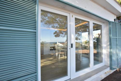 a sliding glass door to a patio with a view of the ocean at BHost - Bungalows Mazagón in Palos de la Frontera