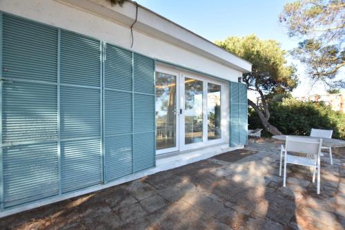 a blue house with a table and a window at BHost - Bungalows Mazagón in Palos de la Frontera