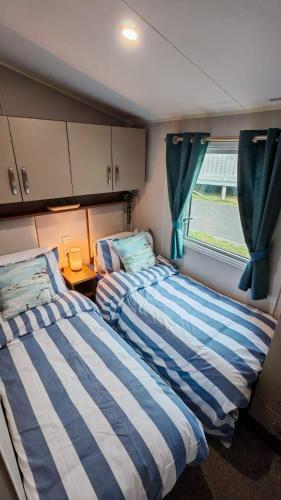 two beds in a small room with a window at The Ocean Nook in New Quay
