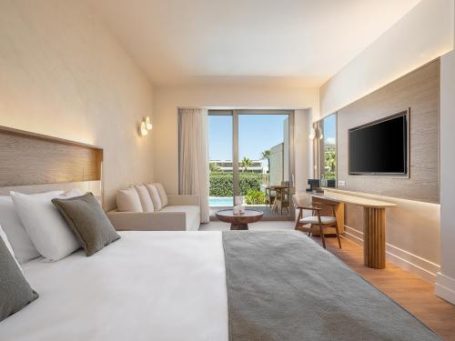 a hotel room with a bed and a television at Avra Imperial Hotel in Kolymvari