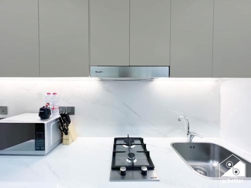Una cocina blanca con fregadero y microondas. en Modern Comfort Studio Relax & Unwind in Style, en Dubái