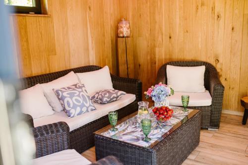 a living room with two wicker chairs and a table with flowers at Zacisze Kaszuby in Gowidlino