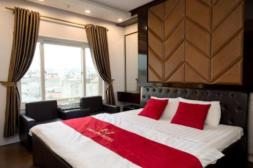 a bedroom with a large bed with red pillows at CHIEN CONG Hotel in Ha Long