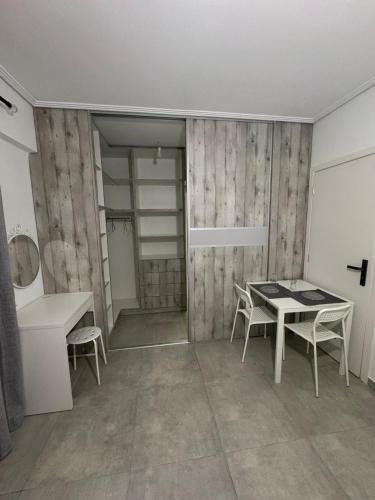 a room with a table and chairs and a bathroom at GuccisCozyStudio in Artemida