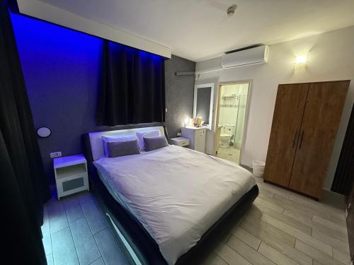 a bedroom with a large white bed with blue lighting at the royal lake views in Tiberias