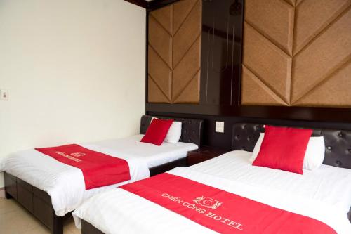 two beds in a room with red and white blankets at CHIEN CONG Hotel in Ha Long