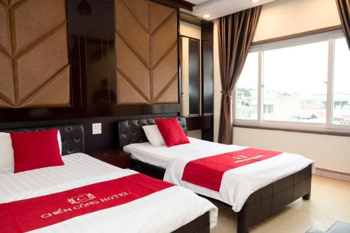 a hotel room with two beds with red and white sheets at CHIEN CONG Hotel in Ha Long