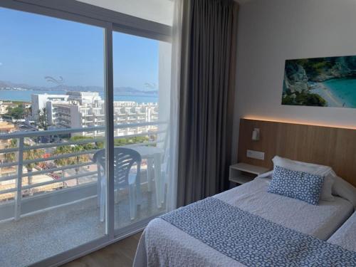 una camera da letto con un letto e un balcone con vista di Hotel Sultán a Can Picafort
