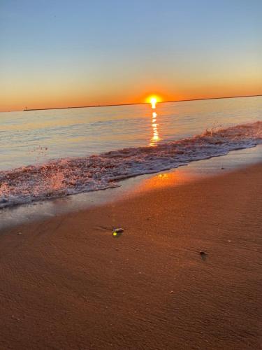 a sunset on the beach with the sun setting at CENTER APARTMENT Mazagón in Mazagón