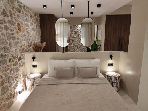 a bedroom with a large bed and two mirrors at Vouros Villages - Suites in Masouri