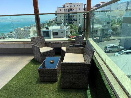 a balcony with chairs and a table on a building at the royal lake views in Tiberias