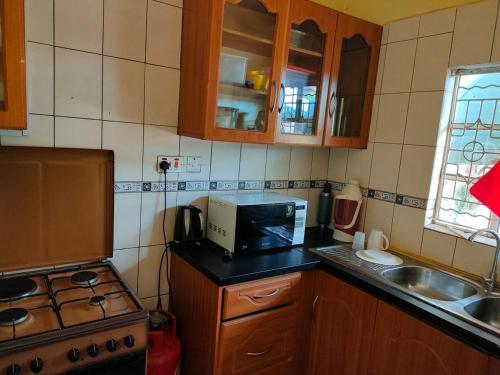 a small kitchen with a sink and a microwave at Eco Lake Chala Garden in Taveta