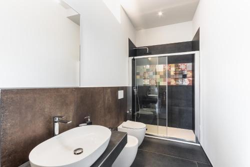 a bathroom with a white toilet and a sink at Palazzo Giangreco Luxury Rooms in Avola