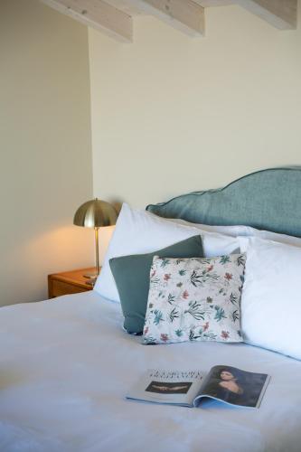 a bed with a pillow and a book on it at Villa Mabel Boutique Hotel in Taormina