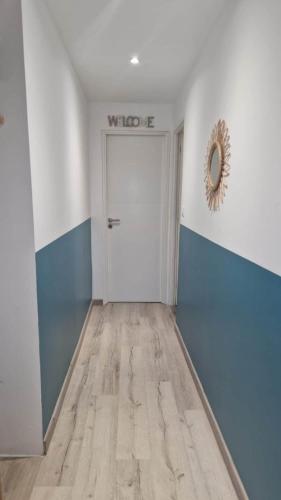 a hallway with a white door and blue and white walls at Studio attenant à une villa in Crémieu