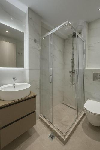 a bathroom with a shower and a sink and a toilet at Studio Lumo in Nea Moudania