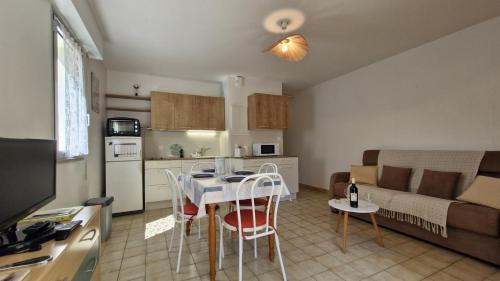 une cuisine et un salon avec une table et des chaises dans l'établissement Saint Georges de Didonne - BEL APPARTEMENT résidence boisée PROCHE MER, à Saint-Georges-de-Didonne