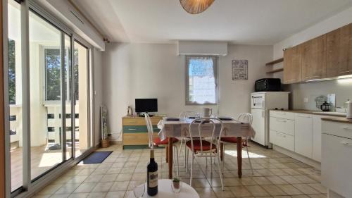- une cuisine avec une table, des chaises, une table et une table dans l'établissement Saint Georges de Didonne - BEL APPARTEMENT résidence boisée PROCHE MER, à Saint-Georges-de-Didonne