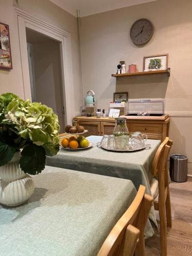 a kitchen with two tables and a clock on the wall at Nice Garden Hotel in Nice