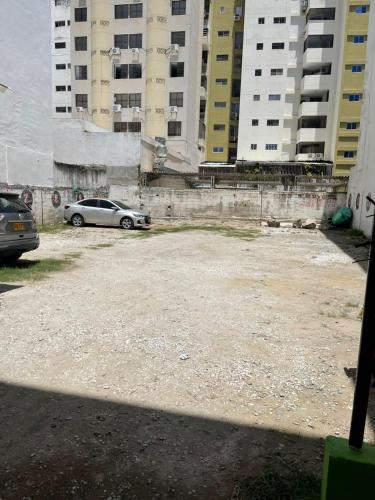 a car parked in a parking lot next to tall buildings at azul caribe 9-10-12-13 in Gaira