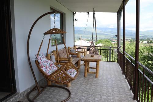 a porch with a swing and a chair at Tesaran Stepanavan Guest House, Apart Hotel in Stepʼanavan