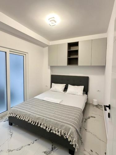 a bedroom with a bed with white walls and a window at MatyMar Blue in Eforie Nord