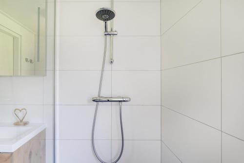 a shower with a shower head in a bathroom at Bonte Vliegenvanger in Zwiggelte