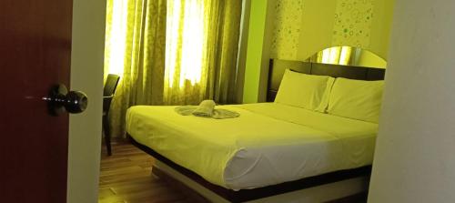 a bedroom with a bed with yellow walls and a window at Hospedaje D'Luis in Lima