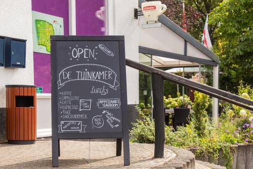 a chalkboard sign in front of a restaurant at Bonte Vliegenvanger in Zwiggelte