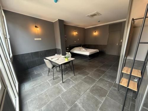 una camera con tavolo e letto di Logements des choraux a Tournai