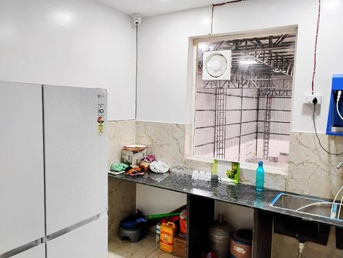 a kitchen with a counter top and a refrigerator at Hotel sky heights in Sonīpat