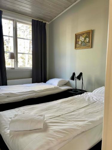two beds sitting next to each other in a bedroom at Bergs Gård & Hållsvikens Gård in Västerljung