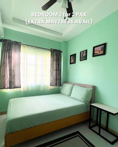 a bedroom with a bed with a window and a table at Lovenista Retreat and Camping Site - Exclusive Stay near Canyoneering in Alegria