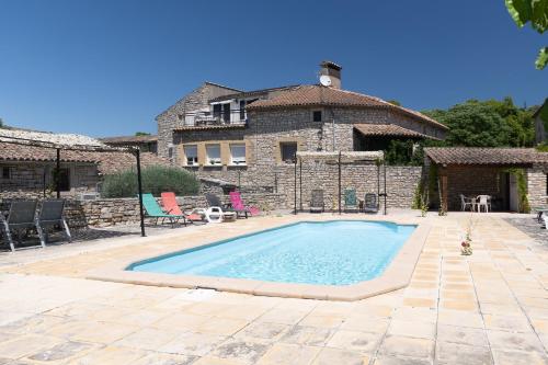 - une piscine en face d'une maison en pierre dans l'établissement Micocoulier de la Maréchale, à Orgnac-lʼAven
