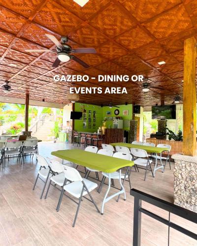 a restaurant with tables and chairs and a ceiling at Lovenista Retreat and Camping Site - Exclusive Stay near Canyoneering in Alegria