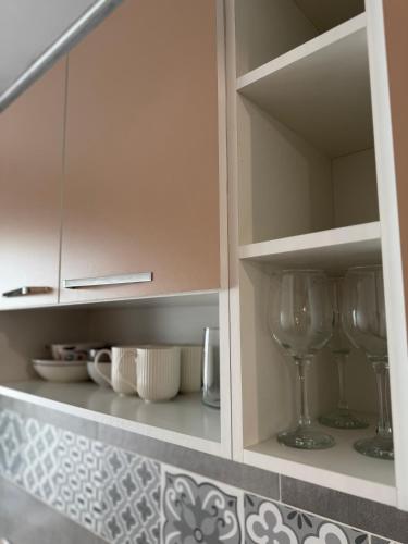 a cupboard with two wine glasses in it at Spacious 2 Bedroom Apartment in Iaşi