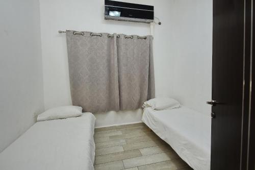 a small room with two beds and a window at the royal lake views in Tiberias