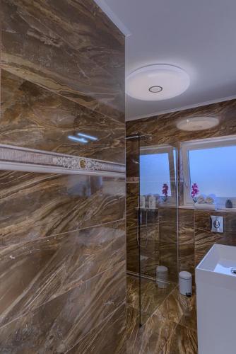a bathroom with a stone wall and a shower at Appartement Ellara Penthouse in Žrnovo