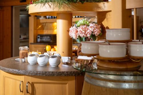 a kitchen counter with bowls and flowers on it at Hotel Tirol- Natural Idyll in Montesover