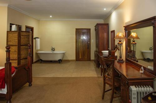 a large bathroom with a tub and a bath tub at Premier Resort Mpongo Private Game Reserve in Macleantown