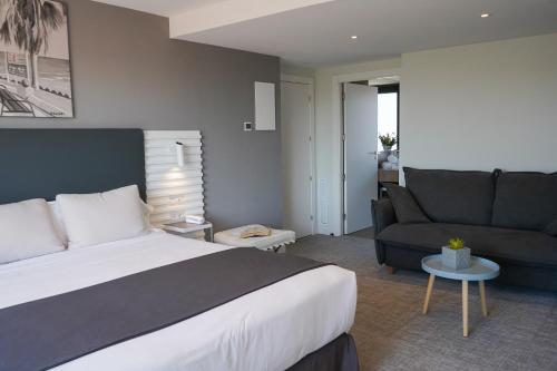 a hotel room with a bed and a couch at Hotel Sitges in Sitges