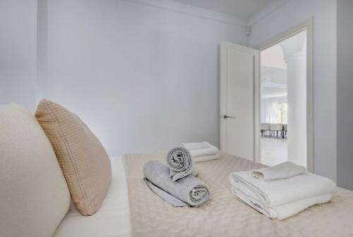 a white bedroom with towels sitting on a bed at Stunning 5 Bedroom Villa in Puerto Banus with Pool in Marbella