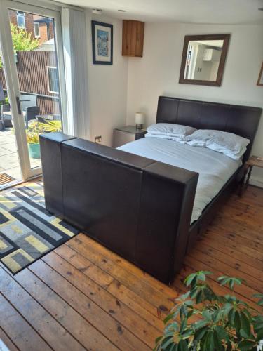 a bedroom with a bed with a black headboard at West Lodge in Hatfield