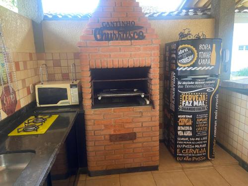 a brick oven in a restaurant with a microwave at Alvorecer do Pepê in Lagoa Santa